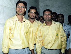 Indian cricketers Ashish Nehra, Murali Karthik and Akash Chopra pose for photographers after their arrival from Pakistan at Indira Gandhi International Airport