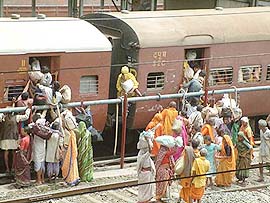 Pilgrims try to board a train in Bhopal on Sunday to leave for a 'shahi snan' during the month-long 'Simhastha Mahakumbh' at Ujjain