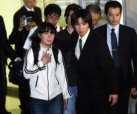 Nahoko Takato, one of the three released Japanese hostages, is escorted by her brother Shuichi Takato on her arrival at Tokyo airport 