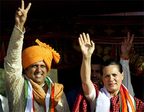 Congress President Sonia Gandhi and Bollywood star and Congress candidate Govinda wave to a large gathering during an election campaign rally in Vasai