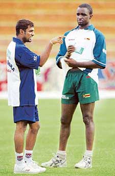Sri Lankan bowler Muttiah Muralitharin chats with Zimbabwe bowler Mluleki Nkala during a practice session in Bulawayo