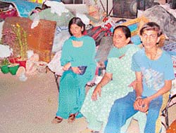 Rendered homeless by her landlady, Anju Mehta and her children are seen guarding their belongings around midnight