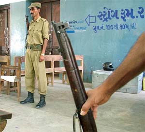 Policemen stand guard outside the strongroom, where EVMs are kept till the completion of voting in Ahmedabad