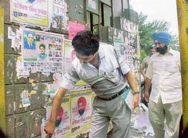 Posters put up by various political parties being removed following directions of election observers