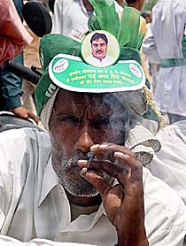 A beedi-smoking man sports a sun shade with the INLD candidate�s picture in Kurukshetra