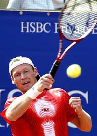 Rainer Schuettler of Germany returns the ball to Tim Henman of Great Britain during their quarter-final match