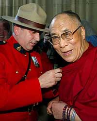 The Dalai Lama receives a pin from Royal Canadian Mounted Police Constable Yvon Brault upon arriving on Parliament Hill in Ottawa on Thursday. The Dalai Lama is on a 19-day tour of Canada.