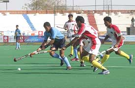 Indian forward Tushar Handker struggles against Bangladeshi defenders during their match at the 5th Junior Asia Cup Field Hockey Tournament in Karachi