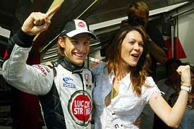Honda Formula One driver Jenson Button of Great Britain celebrates with his girlfriend Louise Griffiths