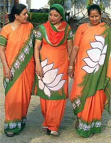 Women activists of the Bharatiya Janata Party dressed in party flags come out of the BJP office