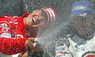 Ferrari Formula One world champion driver Michael Schumacher of Germany celebrates with Honda's Jenson Button of Great Britain