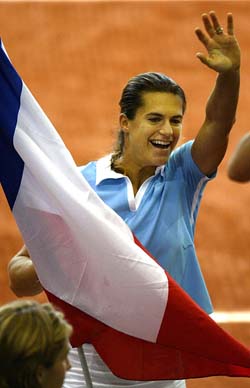 Amelie Mauresmo of France runs with the French flag as she celebrates her team's victory over Germany