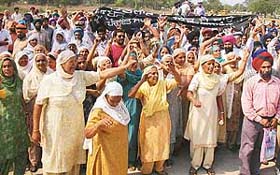 Women raise slogans against the government outside PUDA Bhavan in protest against the acquisition of their land in Mohali
