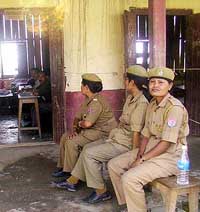 Women police relax in the absence of voters at a polling station at Nambol village in Imphal during the second phase of the Lok Sabha elections on Monday. 