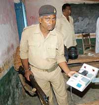 A policeman shows a damaged EVM at booth No. 142 which was ransacked by anti-social elements during the second phase of the Lok Sabha elections in Hajipur, Bihar, on Monday.
