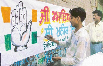 A painter gives finishing touches to a Congress banner in Ludhiana on Tuesday.