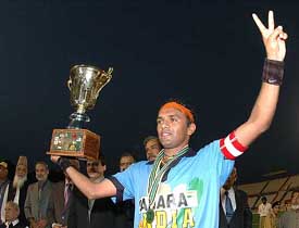 Indian field hockey captain Sandeep Micheal flashes victory sign as he lifts the junior Asia Cup trophy