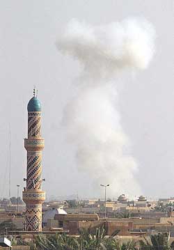 Smoke rises past a minaret in the besieged city of Falluja