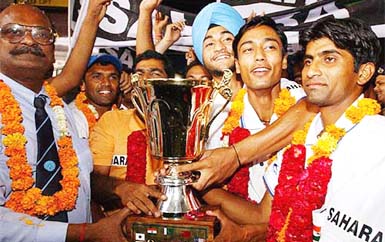 Triumphant members of the junior India hockey team pose with the Asia Cup trophy after their arrival at IGI airport 