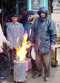 Kashmiris warm themselves after a spell of heavy snowfall