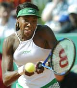 Venus Williams of the United States returns a ball to Vera Zvonareva of Russia during their semifinal match at the Warsaw Cup 