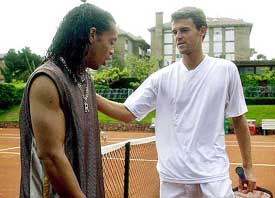 Brazilian tennis player Gustavo Kuerten speaks with Barcelona's soccer player Ronaldihno