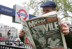 A man reads the Saturday's issue of the Daily Mirror newspaper