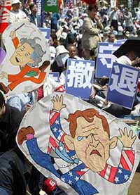 Placards of US President George W. Bush and Japanese Prime Minister Junichiro Koizumi are displayed in protest against US and Japanese troops� presence in Iraq at a May Day rally in Tokyo.