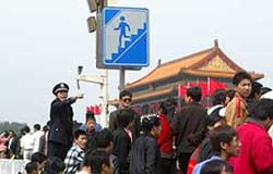 A police officer gives an order to a tourist near Tianamen Gate in central Beijing