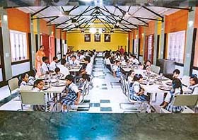 Children enjoying their meal in the spacious mess of the school hostel