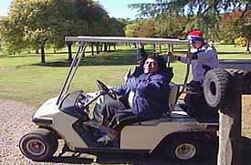 Former Argentine football star Diego Maradona drives a golf cart as he waves to journalists at a country house on the outskirts of Buenos Aires on Saturday