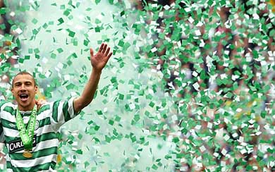Celtic's Swedish striker Henrik Larsson celebrates after Celtic won the Scottish Premier League trophy
