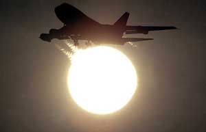 An aircraft descends for landing as the sun rises over New Delhi airport 