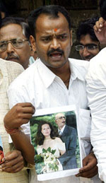 A Congress activist holds a copy of a magazine which he claims published a fabricated image of Congress party president Sonia Gandhi with Deputy Prime Minister L. K. Advani, in Mumbai