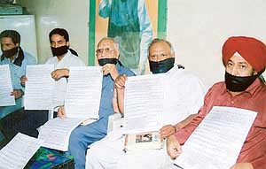 Mr Sat Pal Gosain, president, trade and industry cell of the BJP, along with other functionaries display posters listing Congress �misdeeds� in Ludhiana