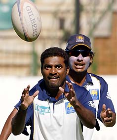 Sri Lanka's Muttiah Muralitharan, watched by teammate Kumar Sangakkara, catches the ball during a game of Australian rules football at a practice session in Harare on Wednesday
