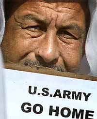 An Iraqi holds an anti-American banner in front of the main gate of the prison of Abu Ghraib near Baghdad on Wednesday
