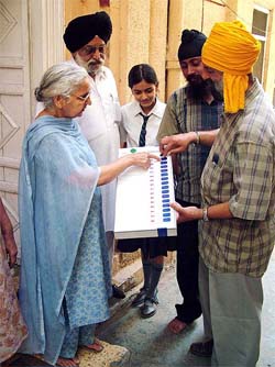 An Akali Dal worker makes voters familiar with the functioning of an electronic voting machine in Jalandhar