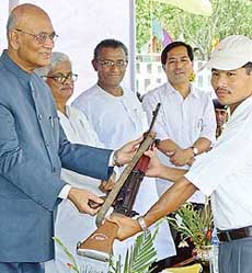 A tribal separatist insurgent (R) belonging to the National Liberation Front of Tripura (NLFT) hands over an assault rifle during a surrender ceremony in Agartala on Thursday.