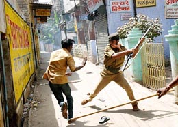 Policemen chase a demonstrator near Ram Mohan Roy School, Patna