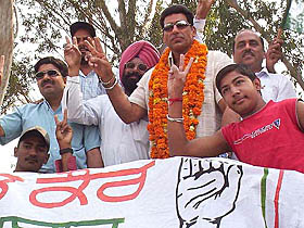 Actor Mukesh Rishi makes the victory sign while campaigning for Congress candidate Preneet Kaur in Patiala