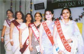 Members of the Gitanjali Ladies Club walk down the ramp displaying their sarees at a cotton saree competition