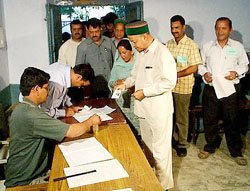 Himachal Pradesh Chief Minister Virbhadra Singh shows his identity card to a polling agent before casting his vote at Rampur in the Mandi parliamentary constituency on Monday.