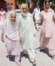 Swaran Kaur (75) and Kartar Kaur (90) come out of A.S. Senior Secondary School, Khanna, after casting their votes. 