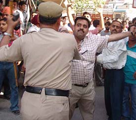 BJP leader Mr Tarun Chugh being manhandled by police at Andh Vidhyalay polling booth in Amritsar