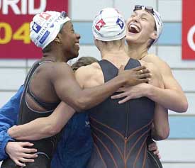 France's Malia Metella, Aurore Mongel and Celine Couderc celebrate after winning the women's 400m freestyle relay race at the European Swimming Championships in Madrid