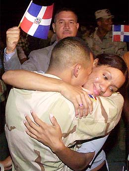 A Dominican soldier embraces his girlfriend as he arrives at Americas International airport in Santo Domingo