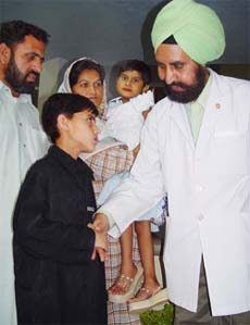 Dr R.S.Dhaliwal, head of the cardio-thoracic department of the PGI, interacts with Pakistani boy Master Matiuallah(11) and Baby Tanzile Malik(6) at Chandigarh