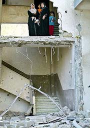 A Palestinian family stands inside their damaged house after the withdrawal of Israeli troops from Zeitoun neighbourhood in Gaza on Thursday.