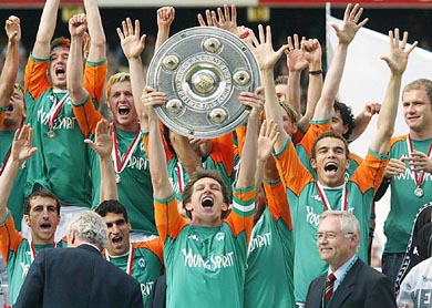 Bremen's captain Frank Baumann raises the German football champions trophy after the Bundesliga match between Werder Bremen and Bayer Leverkusen